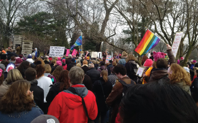 Crowd at Women's March with signs and flags