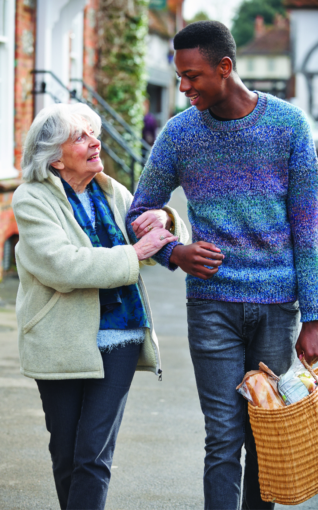 a young man helping old lady with her groceries