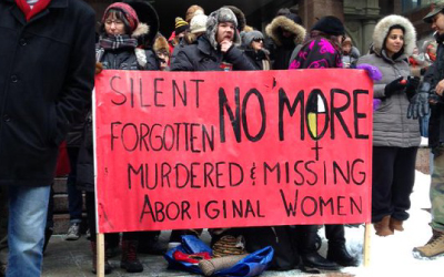 people protesting outside the 10th Annual Strawberry Ceremony in Toronto, sign reads Silent Forgotten No More Murdered and Missing Aboriginal Women