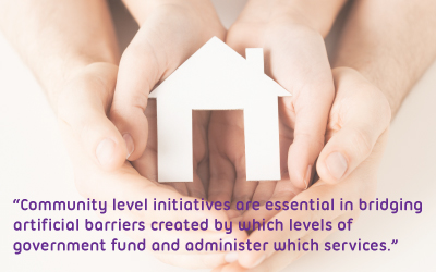 Mother and child's hands cupping a paper cut out of a house, text reads: “Community level initiatives are essential in bridging artificial barriers created by which levels of government fund and administer which services.”