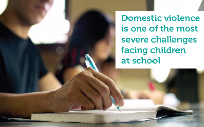  student writing. text reads: domestic violence is one of the most severe challenges facing children at school