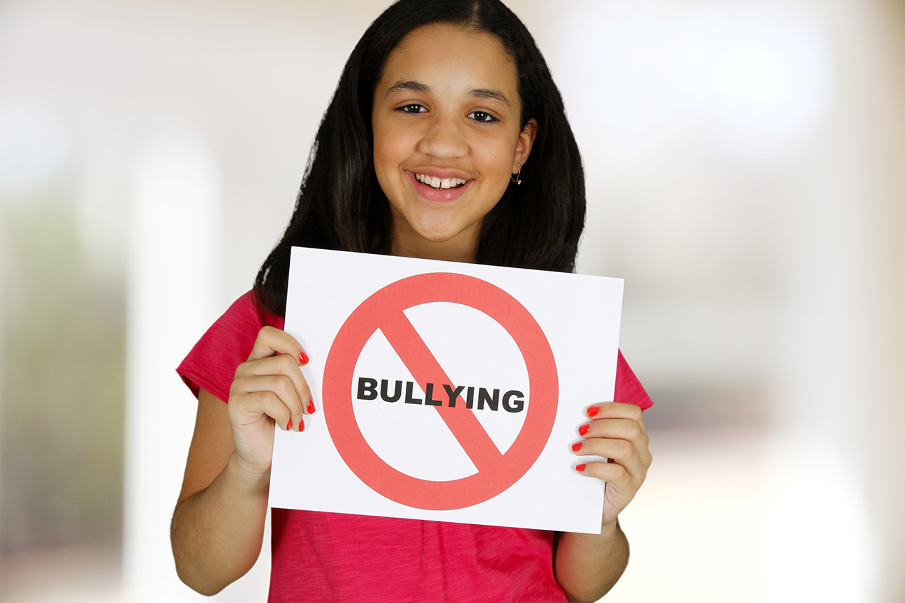 young girl holding anti bullying sign